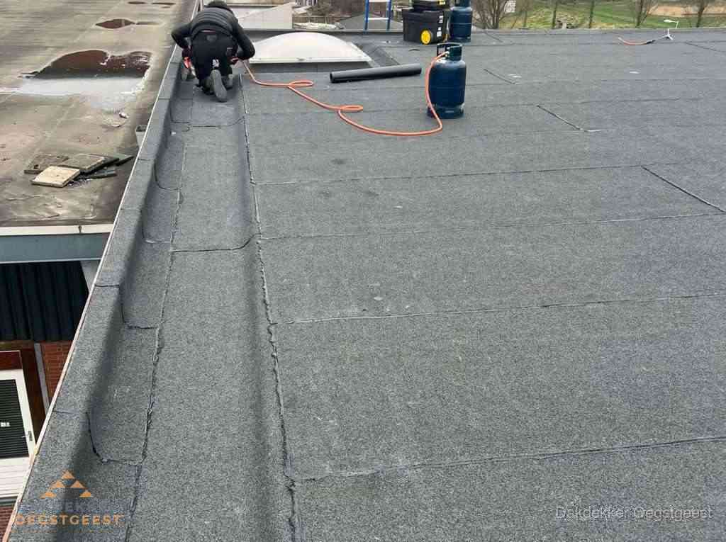 Dakdekker repareert bitumen dakbedekking op groot plat dak in Oegstgeest Dakdekker repareert bitumen dakbedekking op groot plat dak in Oegstgeest